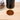 Grosche TOKIO manual coffee grinder for travel with freshly ground coffee on wooden surface.